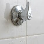 Llave de paso doméstica con pequeña fuga visible en una instalación de baño