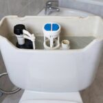 Interior de una cisterna vista con válvula de llenado y mecanismo de descarga