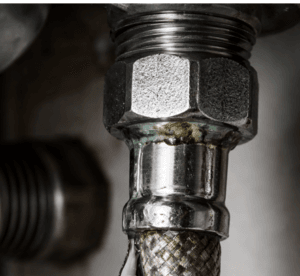 Detalle de latiguillo gotea en una conexión de agua