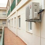 Unidad exterior de aire acondicionado instalada en una fachada de edificio residencial
